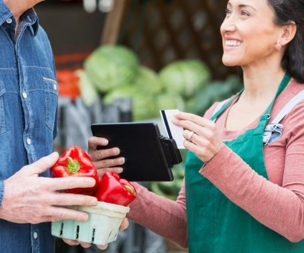 a-man-buying-peppers-with-a-Discover-credit-card